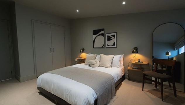 Finished double bedroom with mirror, bedside lighting and dressed bedding in an Oxfordshire rental property